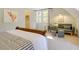 Bright bedroom with sitting area featuring stylish gray couch and plush upholstered ottomans at 1301 Flying Hawk Rd, Apex, NC 27523