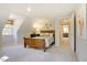 Comfortable bedroom with neutral carpet, dormer window, and a decorative accent wall at 1301 Flying Hawk Rd, Apex, NC 27523