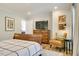 Bright bedroom featuring wood floors, a wood dresser, and an upholstered chair at 1301 Flying Hawk Rd, Apex, NC 27523
