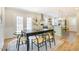 Open concept dining area connected to kitchen, featuring a black table and a patterned rug at 1301 Flying Hawk Rd, Apex, NC 27523