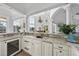 Entertainers bar with wine fridge, marble counters, sink and serving space overlooking the living room at 1404 Barony Lake Way, Raleigh, NC 27614