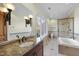 Inviting bathroom featuring a vanity, granite countertop, walk-in shower, and a soaking tub at 1404 Barony Lake Way, Raleigh, NC 27614