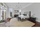A serene bedroom featuring a chandelier, a large bed, a cozy rug, and ample natural light at 1404 Barony Lake Way, Raleigh, NC 27614