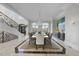 Bright dining room with large windows, a grand chandelier, and a long formal dining table at 1404 Barony Lake Way, Raleigh, NC 27614