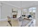 Bright living room with a stone fireplace, chandelier, and access to an outdoor balcony at 1404 Barony Lake Way, Raleigh, NC 27614