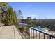 Stunning view of the backyard pool and lake from the balcony, framed by lush greenery at 1404 Barony Lake Way, Raleigh, NC 27614