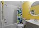 Bright bathroom with yellow wall, whale shower curtain and round mirror at 1425 Country Pond Ln, Willow Springs, NC 27592