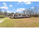 Single-story home with a well-manicured front yard, complete with a deck, perfect for outdoor enjoyment at 1425 Country Pond Ln, Willow Springs, NC 27592