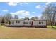 Charming single-story home with a red front door and a well-maintained lawn on a sunny day at 1425 Country Pond Ln, Willow Springs, NC 27592