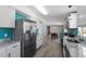 Bright kitchen with granite countertops, stainless steel fridge, and modern appliances leading to dining area at 1425 Country Pond Ln, Willow Springs, NC 27592