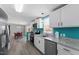 Open-concept kitchen with stainless steel appliances and teal accent walls leading into dining area at 1425 Country Pond Ln, Willow Springs, NC 27592