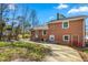 Side and back of house showing brick construction and backyard with grass and trees at 1506 N Mebane St, Burlington, NC 27217