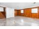 Large basement with wood paneling has staircase to upper level and access to natural light from two windows at 1506 N Mebane St, Burlington, NC 27217