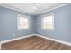 Bedroom featuring two windows, a ceiling fan, and hardwood floors at 1506 N Mebane St, Burlington, NC 27217
