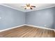 A well-lit bedroom with smooth wood flooring and calming blue walls at 1506 N Mebane St, Burlington, NC 27217