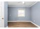 Bedroom featuring blue walls, hardwood floors, and a window at 1506 N Mebane St, Burlington, NC 27217