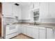 Bright kitchen featuring white appliances and cabinetry with a window above the sink at 1506 N Mebane St, Burlington, NC 27217