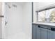 This shower has white tile and a window that provides a view of the outdoors and allows light in at 1506 N Mebane St, Burlington, NC 27217