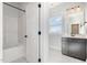 Bright bathroom with a shower-tub combo, white tile, and a dark vanity with a framed mirror above it at 1515 Spring Overlook Ln, Hillsborough, NC 27278