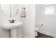 Clean powder room featuring a pedestal sink, toilet, and wood-look flooring at 1515 Spring Overlook Ln, Hillsborough, NC 27278