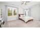 Sunlit bedroom featuring neutral walls, carpet, a ceiling fan, and a large window overlooking the outdoor landscape at 1515 Spring Overlook Ln, Hillsborough, NC 27278