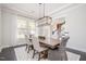Elegant dining room with a modern chandelier, wooden table, and ample seating for guests at 1515 Spring Overlook Ln, Hillsborough, NC 27278