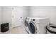 Bright laundry room with a washer and dryer, white door, and a laundry hamper at 1515 Spring Overlook Ln, Hillsborough, NC 27278