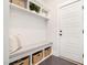 Mudroom with white shelving, coat hooks, seating area, and woven baskets for storage at 1515 Spring Overlook Ln, Hillsborough, NC 27278