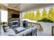 Covered outdoor living space with a stone fireplace, TV, grill, and comfortable seating area at 1515 Spring Overlook Ln, Hillsborough, NC 27278