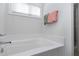Bright bathroom features a soaking tub with a shower and a large window for natural light at 1613 Osprey Ridge Dr, Willow Springs, NC 27592
