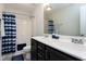 Bright bathroom featuring double vanity, shower with curtain, and neutral color palette at 1613 Osprey Ridge Dr, Willow Springs, NC 27592