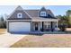 Charming single-Gathering home with gray siding, stone accents, a two-car garage, and a well-manicured front yard at 1613 Osprey Ridge Dr, Willow Springs, NC 27592