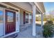 Close-up of a welcoming front porch, featuring a decorative glass door and white support columns at 1613 Osprey Ridge Dr, Willow Springs, NC 27592