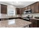 Well-equipped kitchen with granite counters, stainless steel appliances, dark cabinets, and a functional layout at 1613 Osprey Ridge Dr, Willow Springs, NC 27592