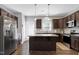 Modern kitchen with stainless steel appliances, granite countertops, dark wood cabinets, and a functional island at 1613 Osprey Ridge Dr, Willow Springs, NC 27592