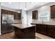 Well-designed kitchen featuring dark cabinetry, a granite-topped island, stainless steel appliances, and a convenient back door at 1613 Osprey Ridge Dr, Willow Springs, NC 27592