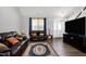A comfortable living room with hardwood floors, a large TV, a dark sofa, and ample space for relaxing and entertaining at 1613 Osprey Ridge Dr, Willow Springs, NC 27592