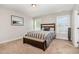 Cozy bedroom featuring a wooden bed frame, neutral walls, and carpet at 19 Tobenton Ct, Clayton, NC 27520