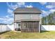 View of the home's back exterior, including a screened-in porch and large yard at 19 Tobenton Ct, Clayton, NC 27520