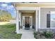 Inviting front entrance with a covered porch, stone accents, and a stylish black front door at 19 Tobenton Ct, Clayton, NC 27520