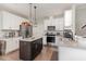 Bright kitchen boasts white cabinets, granite countertops, stainless steel appliances and dark wood island at 19 Tobenton Ct, Clayton, NC 27520