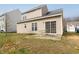Backyard with patio, glass sliding doors to yard and outdoor space, with green lawn and blue sky in the background at 1945 Red Quartz Dr, Raleigh, NC 27610