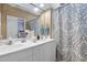 Bathroom with a double vanity, large mirror, and a blue and brown patterned shower curtain at 1945 Red Quartz Dr, Raleigh, NC 27610