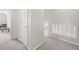 Bright upstairs hallway with neutral walls and carpet, offering a serene transition between rooms at 1945 Red Quartz Dr, Raleigh, NC 27610