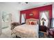 Main bedroom featuring a red accent wall, white trim, and a cozy seating area at 1945 Red Quartz Dr, Raleigh, NC 27610