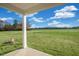 Covered porch with a view of a spacious green field under a sunny sky, perfect for relaxing at 195 Hawksmoore Ln, Lillington, NC 27546