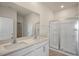 Modern bathroom featuring a double vanity, white cabinets, and a glass-enclosed shower at 195 Hawksmoore Ln, Lillington, NC 27546