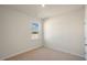 An empty bedroom featuring neutral carpet, light walls, and a window overlooking the yard at 195 Hawksmoore Ln, Lillington, NC 27546