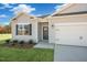 Inviting single-story home with gray siding, a two-car garage, and a well-maintained lawn at 195 Hawksmoore Ln, Lillington, NC 27546