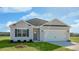Attractive single-story home with gray siding, a two-car garage, and a lush green lawn at 195 Hawksmoore Ln, Lillington, NC 27546
